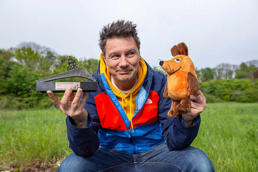 Moderator André Gatzke und die Maus mit der Auszeichnung Fahrradfreundlichste Persönlichkeit 2024. Moderator André Gatzke und die Maus mit der Auszeichnung Fahrradfreundlichste Persönlichkeit 2024.