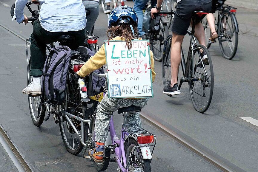 Demo Berlin Radwege-Stopp Ein kleines Mädchen auf dem Fahrrad von hinten mit einem Schild auf einer Demonstration gegen den Radwege-Stopp in Berlin.
